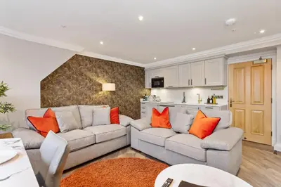 a living room with a gray couch and orange pillows at Central Edinburgh Prime Luxury in Edinburgh