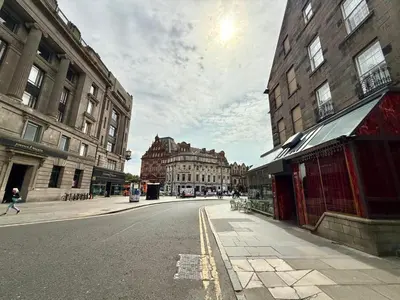 an empty street in a city with tall buildings at Central Edinburgh Prime Luxury in Edinburgh
