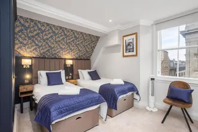 a hotel room with two beds and a window at Central Edinburgh Prime Luxury 3 bed in Edinburgh