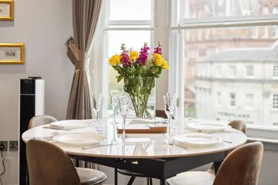 a dining room table with a vase of flowers on it at Central Edinburgh Prime Luxury 3 bed in Edinburgh