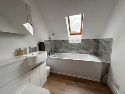 a white bathroom with a tub and a sink at Highland Nook in Fort William