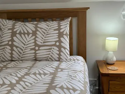 a bed with a pillow and a lamp on a night stand at Highland Nook in Fort William