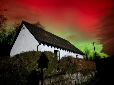 a white building with a roof under a colorful sky at Highland Nook in Fort William