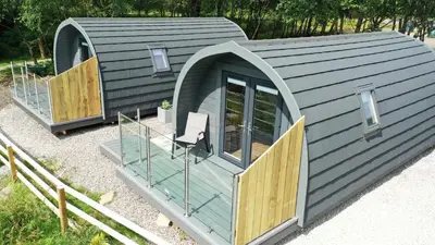 a modular house with a deck and a chair in it at Loch Leven Pods in Kinlochleven