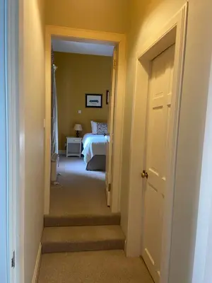 a hallway leading to a bedroom with a bed at Fordie South Cottage in Comrie