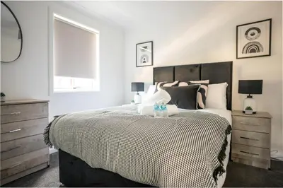 a bedroom with a large bed and a window at Mercer Apartment in Alloa