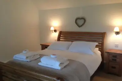 a bedroom with a bed with towels on it at The Dairy Cottage, Loch Tay, Hot Tub and Garden in Lawers