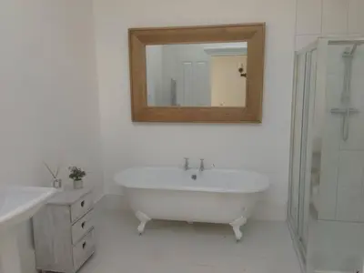 a white bathroom with a tub and a mirror at The Dairy Cottage, Loch Tay, Hot Tub and Garden in Lawers