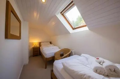 a attic room with two beds and a window at The Barn on Loch Tay - Hot Tub in Lawers