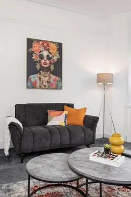a living room with a couch and a table at Stylish Stay in Inverkeithing. in Fife