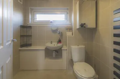 a small bathroom with a toilet and a sink at 2-Bedroom Home Away From Home in Glasgows' East End with FREE Parking in Mount Vernon
