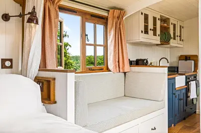 a small kitchen with a bed in a tiny house at Quercus & Redwood - Sleeps 4 in Moffat