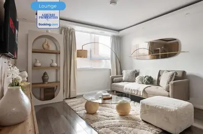 a living room with a couch and a table at Cozy 4-Bedrooms House By Azzurri Properties Short Lets & Serviced Accommodation London With Private Garden, Wi-Fi in Moffat