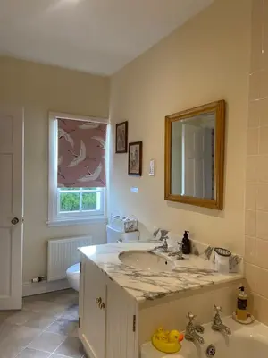 a bathroom with a sink and a toilet and a mirror at Fordie East Cottage in Comrie