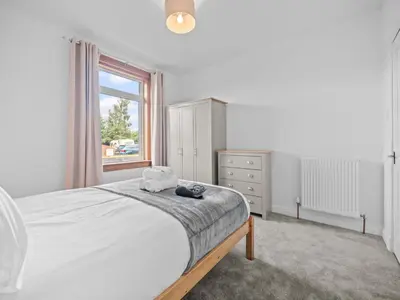 a white bedroom with a bed and a window at Whiteside 3 Bedroom Apartment - Bathgate in Bathgate