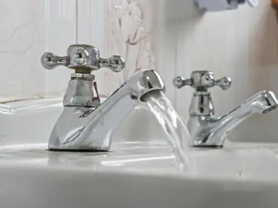 a bathroom sink with two faucets on it at Whiteside 3 Bedroom Apartment - Bathgate in Bathgate