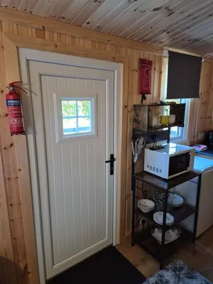a door leading into a kitchen with a microwave at Blair snug hut 2 in Kelty