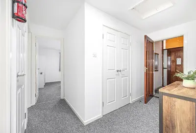 a room with white walls and a hallway with white doors at City Centre Apartment in Dunfermline