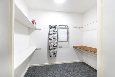a walk in closet with white walls and shelves at City Centre Apartment in Dunfermline