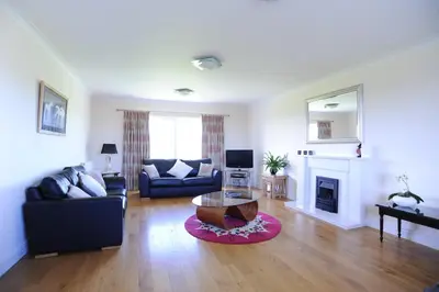 a living room with a couch and a coffee table at Llygad yr Haul in Moffat