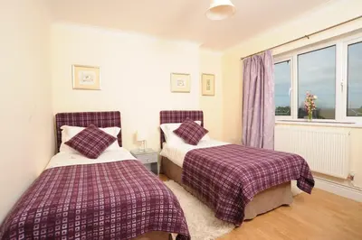 a bedroom with two beds and a window at Llygad yr Haul in Moffat