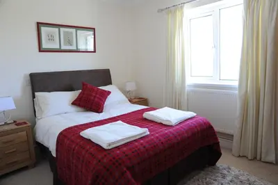 a bedroom with a bed with two towels on it at Llygad yr Haul in Moffat