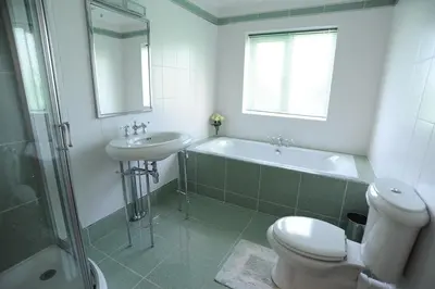 a bathroom with a sink and a tub and a toilet at Llygad yr Haul in Moffat