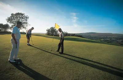 a group of people playing golf on a golf course at Llygad yr Haul in Moffat