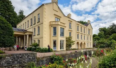 a large yellow building with flowers in front of it at Llygad yr Haul in Moffat