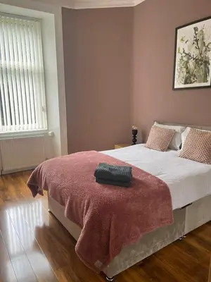 a bedroom with a bed with a red blanket on it at 3BR Apt Near Ibrox Subway Sleeps 7 and Parking in Glasgow