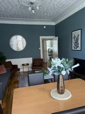 a living room with a vase of flowers on a table at 3BR Apt Near Ibrox Subway Sleeps 7 and Parking in Glasgow