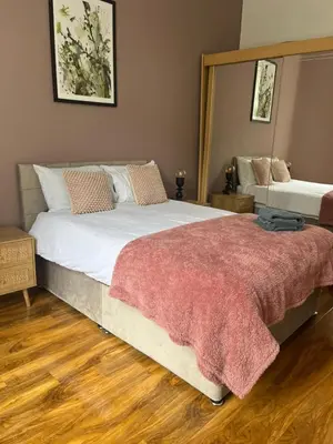 a bedroom with a large bed with a red blanket at 3BR Apt Near Ibrox Subway Sleeps 7 and Parking in Glasgow