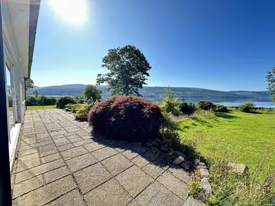 a walkway leading to a yard with a bush at Avenue Cottage, Inveraray in Inveraray