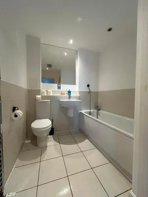 a bathroom with a toilet and a tub and a sink at Waterfront Spacious Flat in Edinburgh