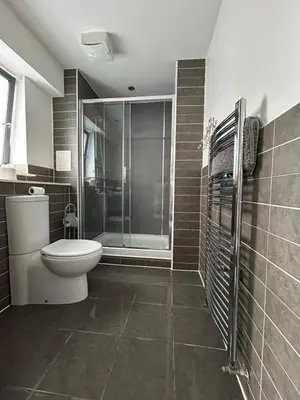 a bathroom with a toilet and a glass shower at Waterfront Spacious Flat in Edinburgh