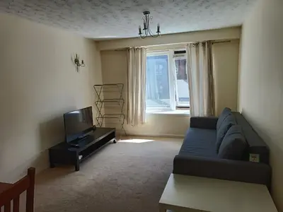a living room with a blue couch and a tv at this flat is permenantly removed from bkngcom list in Moffat