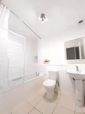 a white bathroom with a toilet and a sink at this flat is permenantly removed from bkngcom list in Moffat