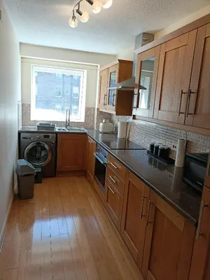 a large kitchen with wooden cabinets and a window at this flat is permenantly removed from bkngcom list in Moffat