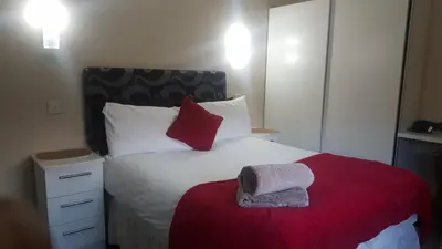 a bedroom with a bed with red and white pillows at My Glasgow House Bishopbriggs in Bishopbriggs