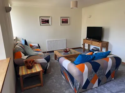a living room with two couches and a tv at Easter Auchencarroch Farm B&B in Balloch