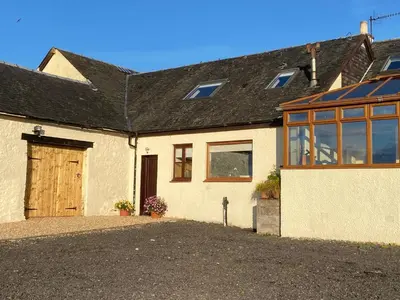 a white house with a large door and windows at Easter Auchencarroch Farm B&B in Balloch