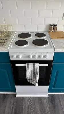 a white stove in a kitchen with blue cabinets at Seaview apartment in Rothesay in Rothesay