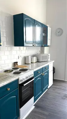 a kitchen with blue cabinets and a stove top oven at Seaview apartment in Rothesay in Rothesay