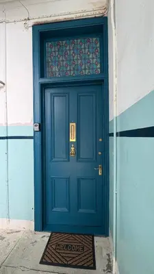 a blue door on a building with a mat in front at Seaview apartment in Rothesay in Rothesay