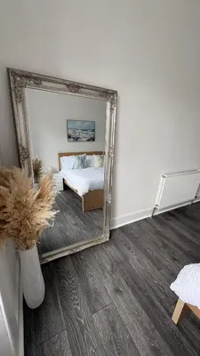 a mirror in front of a bedroom with a bed at Seaview apartment in Rothesay in Rothesay