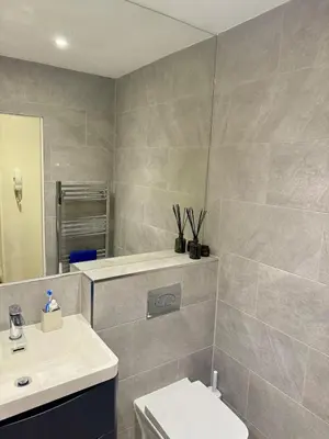 a bathroom with a sink and a toilet and a mirror at Cosy apartment near Edinburgh city centre in Edinburgh