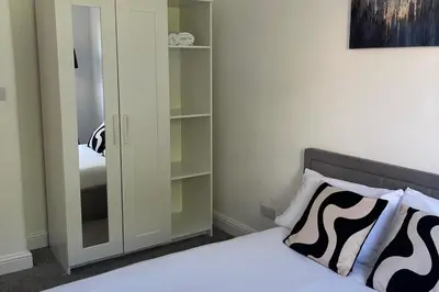 a bedroom with a bed and a closet with a mirror at Glasgow City Apartment with 2 Bedrooms in Glasgow