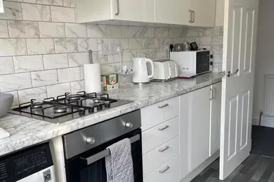 a kitchen counter with a stove and a microwave at Glasgow City Apartment with 2 Bedrooms in Glasgow