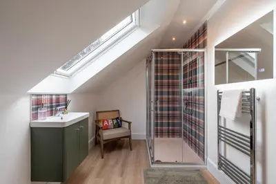 a bathroom with a sink and a shower in a attic at Strathfillan Lodge in Crianlarich