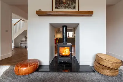 a fireplace in a living room with a wood stove at Strathfillan Lodge in Crianlarich
